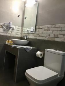 a bathroom with a white toilet and a sink at Platanos Rooms in Anopoli Sfakion