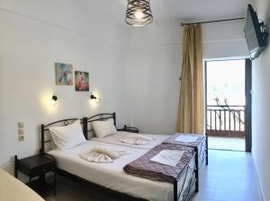 a bedroom with a bed with towels on it at Platanos Rooms in Anopoli Sfakion