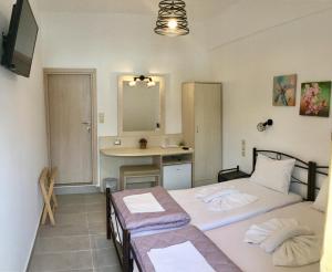 two twin beds in a room with a kitchen at Platanos Rooms in Anopoli Sfakion