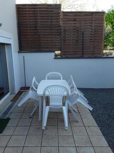 une table blanche et des chaises assises sur une terrasse dans l'établissement Duc's House, à Frozes