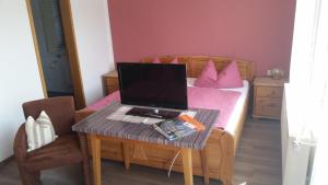 a laptop computer sitting on a table in a bedroom at Gasthof Zur frohen Einkehr in Reichardsroth