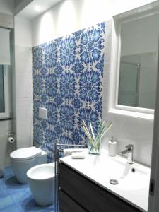 a bathroom with a sink and a toilet and blue tiles at L'antica Vigna in Letojanni
