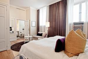 a hotel room with a large bed and a chair at Hotel Villa Anna in Uppsala