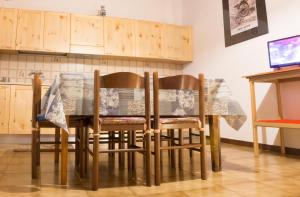 a dining room table and chairs with a table and cabinets at Bilocale indipendente tellino in Teglio