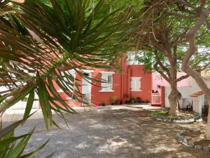 une maison rouge avec des arbres devant elle dans l'établissement Tazacorte Puerto, à Casa Nueva