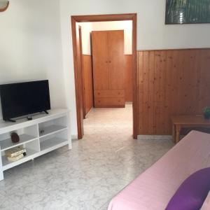 a living room with a television and a room with a door at Tazacorte Puerto in Casa Nueva