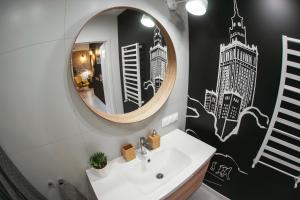 a bathroom with a sink and a mirror at Barson Apartments in Warsaw