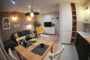 una cucina e un soggiorno con tavolo e divano di Barson Apartments a Varsavia