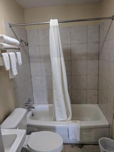 a bathroom with a tub and a toilet and a sink at Benton Inn in Benton