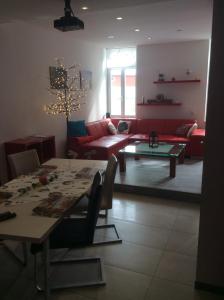 a living room with a table and a red couch at ZUM LÖWE in Waltershausen