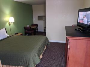 a hotel room with a bed and a flat screen tv at Benton Inn in Benton