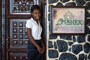 a young woman standing in front of a door at Coral Strand Smart Choice in Beau Vallon