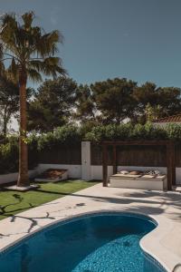 una piscina en un patio con una palmera en Villa Fernweh - Delta de l'Ebre, en Riumar