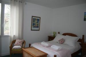 a bedroom with a bed and a chair and a window at Les Rochers in Saint-Étienne-de-Gourgas +25 photos