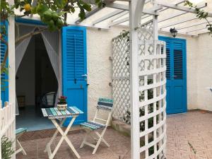a patio with blue doors and a table and a chair at La Casa del Limoneto in Favignana