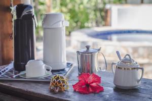 a picnic table with a tea pot and cups and flowers at Planeta Banana Paraty in Paraty