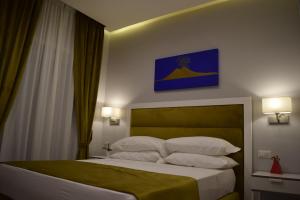 um quarto com uma cama grande e almofadas brancas em Gea suite em Nápoles
