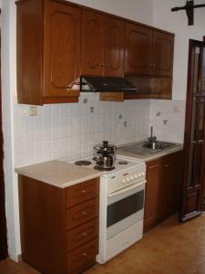 a kitchen with wooden cabinets and a white stove top oven at Elena Studios in Chania