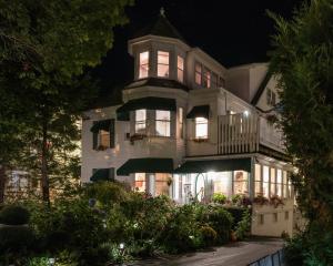 ein großes weißes Haus mit Balkon in der Nacht in der Unterkunft Harbour Towne Inn on the Waterfront in Boothbay Harbor