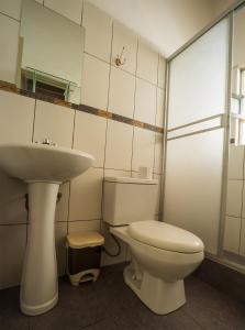 a bathroom with a white toilet and a sink at Hostal Catequil in Cajamarca