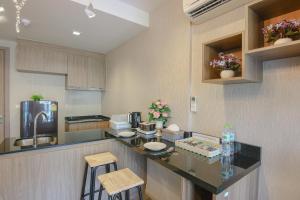 a kitchen with a counter and some stools in it at The Rain Cha Am by Paka in Cha Am