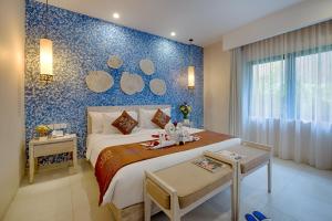 Un dormitorio con una cama grande con una pared azul. en Natya Hotel Gili Trawangan, en Gili Trawangan 21 fotos más
