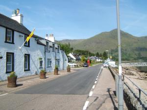 a street in a town with mountains in the background at Inn at Ardgour in Onich