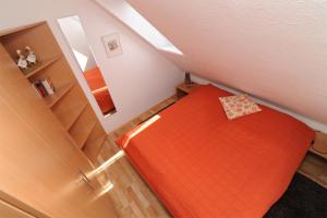 グレートジールにあるFerienwohnung Sonnenkieker Greetsielの小さなベッドルーム1室(屋根裏にオレンジのベッド1台付)