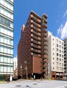 un edificio alto in una strada di città con edifici di Nishitetsu Inn Nihonbashi a Tokyo