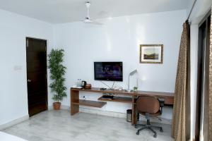 een bureau met een computer en een stoel bij Tatvam Residency in Calcutta