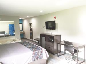 a hotel room with a bed and a flat screen tv at Americas Best Value Inn & Suites Mont Belvieu Houston in Eldon