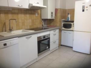 Una cocina con electrodomésticos blancos y un refrigerador blanco. en Pietralba Saint Joseph, en Ajaccio