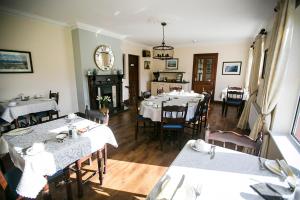 a dining room with tables and chairs and a fireplace at Moloney House in Doolin