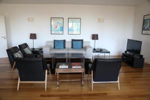 a living room with a couch and chairs and a tv at Casa dos Arcos in Caramulo