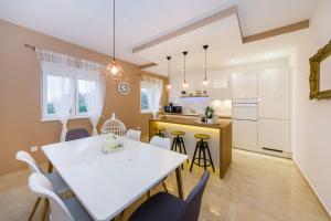 a kitchen and dining room with a white table and chairs at Little Dream in Poljana