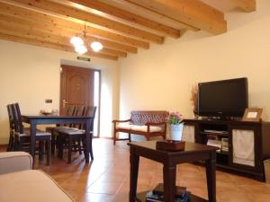 sala de estar con TV y mesa con sillas en Casa Lindelagua, en Pámanes