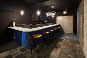 a bar with wooden stools at a blue counter at Ya Do! KYOTO OKAZAKI in Kyoto