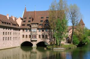 un vecchio edificio con un ponte sul fiume di Vida Real Estate Nürnberg a Norimberga