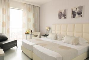 מיטה או מיטות בחדר ב-St George Beach Hotel & Spa Resort