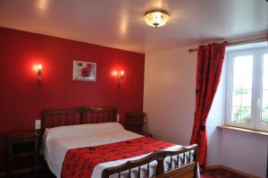 a bedroom with a bed with red walls and a window at Chambres D'hôtes au Saint Avit in Huisnes-sur-Mer