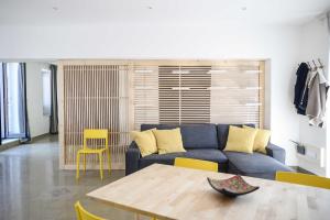 een woonkamer met een blauwe bank en een tafel bij Case Vacanze - Antico Corso in Catania