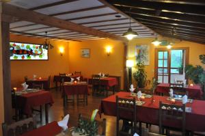 a dining room with red tables and chairs at Hotel Torrecerredo in Arenas de Cabrales