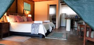 a bedroom with a large bed and a sink at Kingfisher Bush Lodge in Enkovukeni