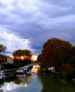 a bridge over a river with boats in the water at La Maison des Palmiers in Homps