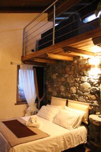 a bed in a room with a stone wall at B&B Lo Matsòn in Chambave