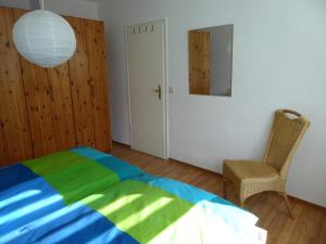 sypialnia z łóżkiem, krzesłem i lustrem w obiekcie LICHTenstein w mieście Lichtenstein