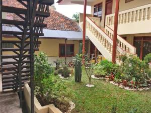 einen Garten vor einem Gebäude mit einer Treppe in der Unterkunft Indekost Bogor in Bogor