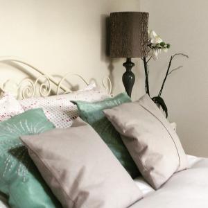 a pile of pillows on a bed with a lamp at Hillside Cottage in Wirksworth