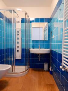 a blue tiled bathroom with a sink and a shower at S127 - Sirolo, nuovissimo monolocale con terrazzo in Sirolo