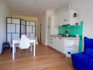 シローロにあるS127 - Sirolo, nuovissimo monolocale con terrazzoのキッチン、ダイニングルーム(白いテーブル、椅子付)